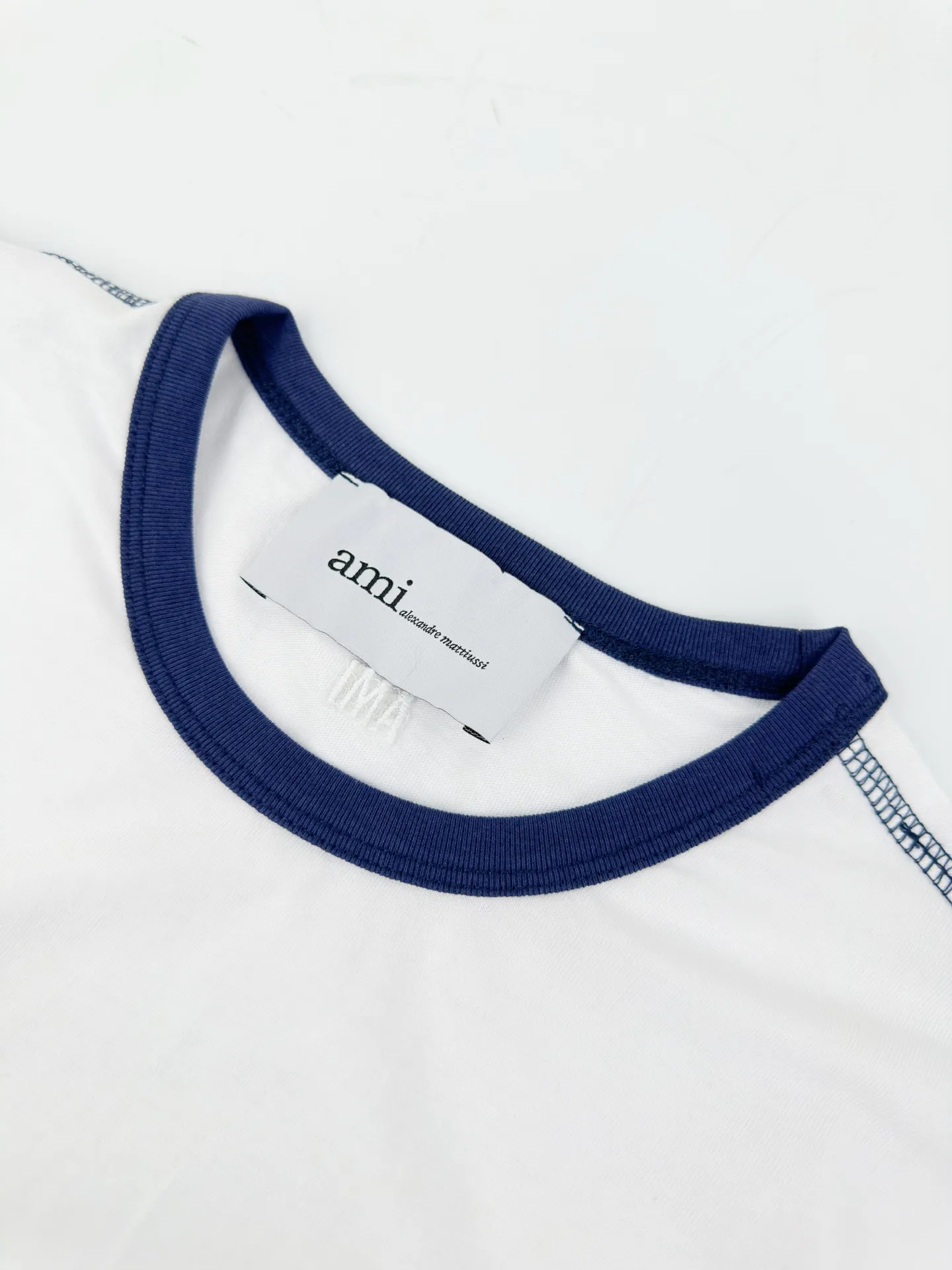 Crocheted love short sleeves. Customized cloud-like ice-soft combed cotton. Delicate, soft and comfortable. Breathable. Mist white and pure Navy Blue trim. French color contrast brings coolness and nobility. The crocheted love heart on the chest embodies French craftsmanship. The three-dimensional texture hides elegance. It shows high-end and gentle style. Ami letter embroidery hides the back collar. Delicate stitching is hidden between the texture. It is low-key and unobtrusive. It shows the French light luxury style in silent places. Craftsmanship 1: Adopt imported machine embroidery seal technology, use advanced computer control system and precision mechanical components to realize the Ami crochet love logo operation with high precision and smooth and delicate lines. Process 2: The fabrics have been fermented and washed for better hand texture. Not easy to deform, not easy to shrink, not easy to fade, and maintain long-term beauty. Accessories: Customized 1:1 Ami trademark. Version: Loose version. Size: S M L XL. Style number: BB 841.